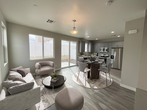 a renovated living room and kitchen with a dining room table and chairs